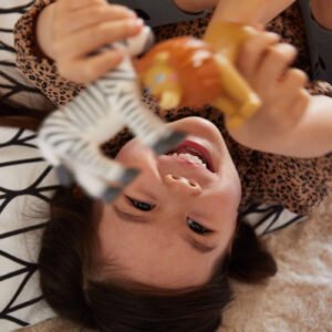 Child playing with Little Friends zebra and lion on a patterned rug