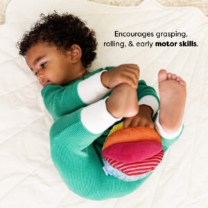 A child in a green outfit lies on a white quilt, holding a colorful stuffed ball. Text reads 