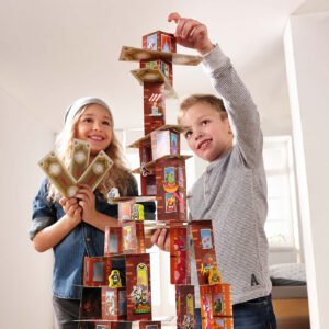Girl holding Rhino Hero Super Battle cards looking at boy reaching up to place a card on top of a card tower